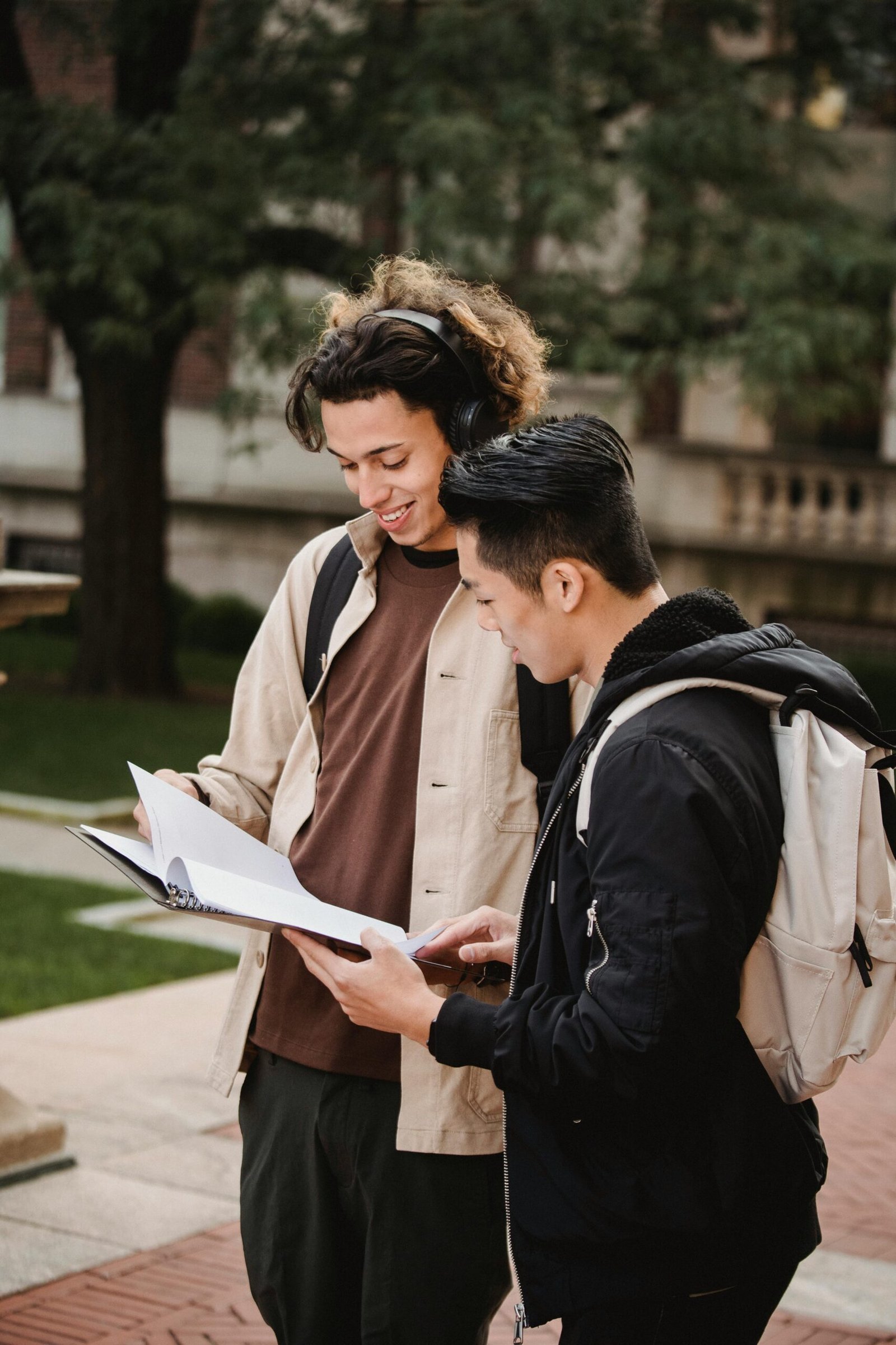 Multiethnic students reading document in folder